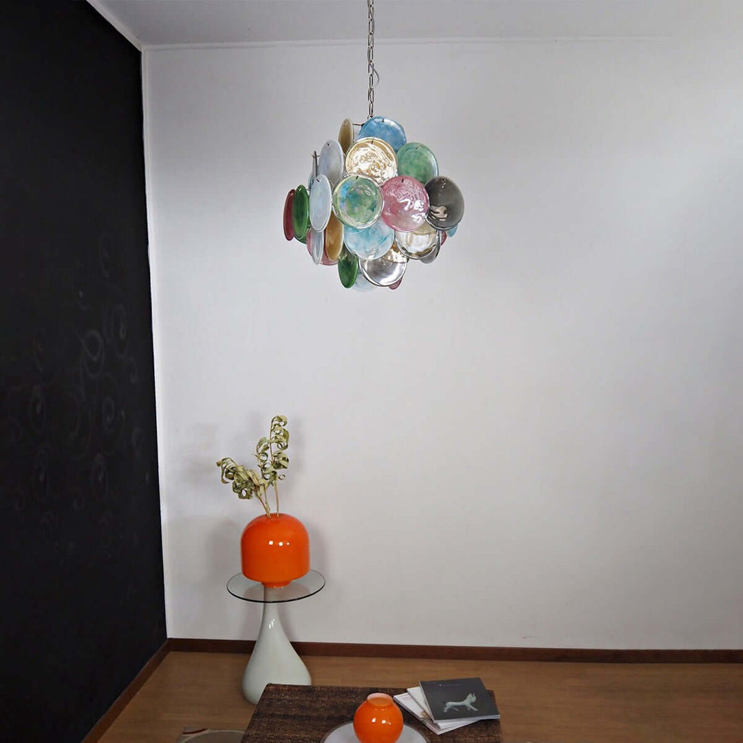 Multicolor Murano glass chandelier suspended in a modern room with orange decorative accents