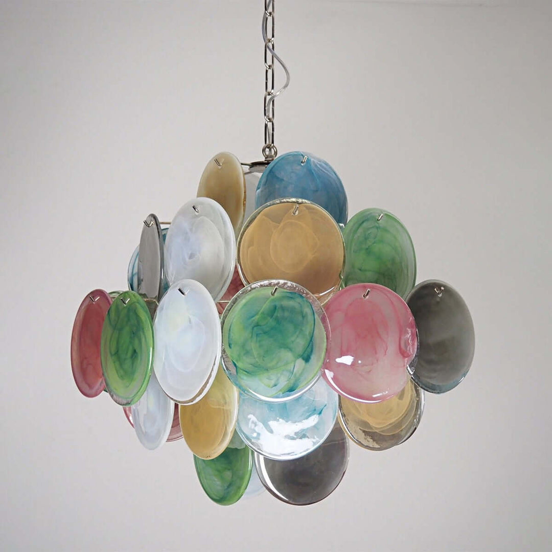 Unlit multicolor Murano glass chandelier with overlapping circular discs on a light wall