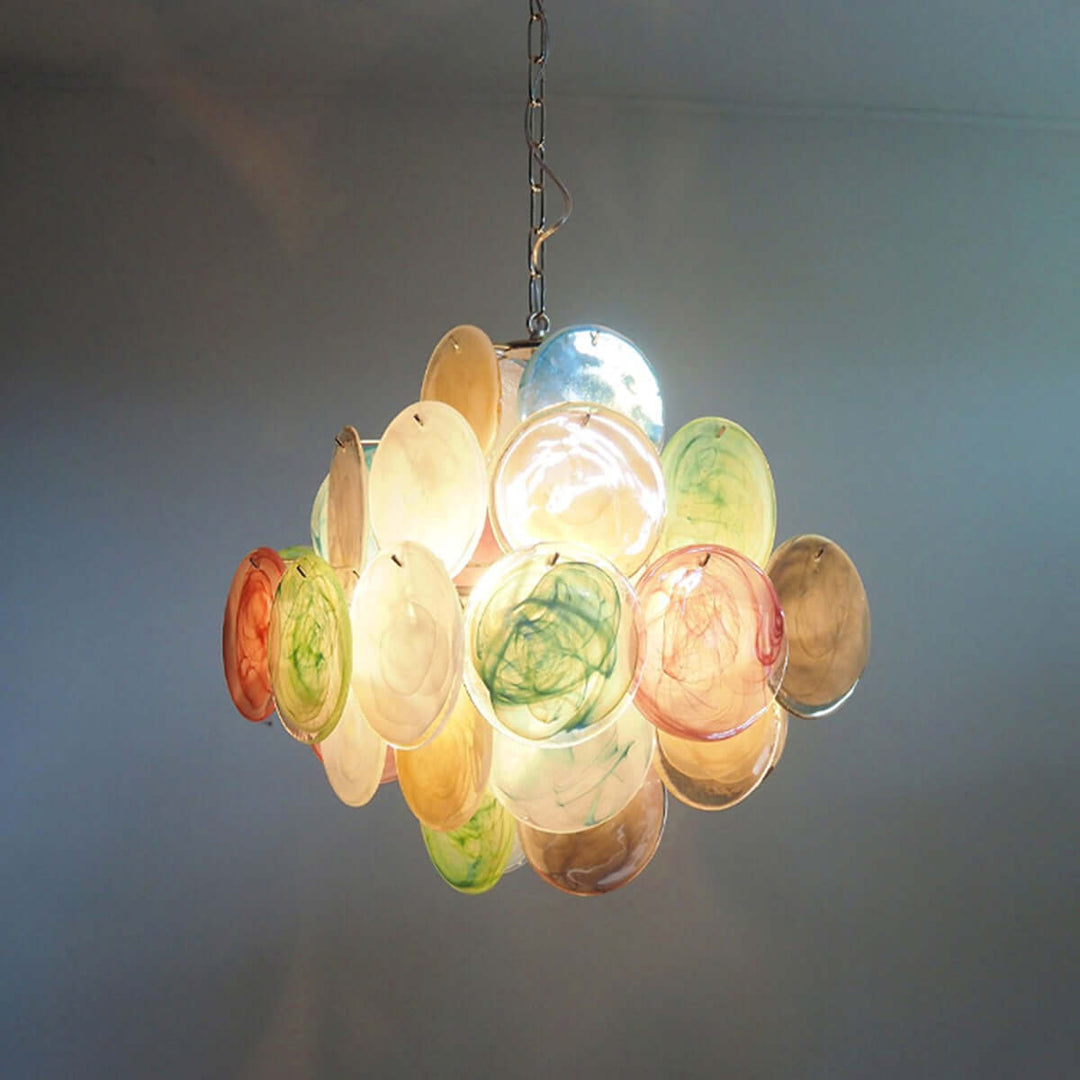 Front view of a glowing multicolor Murano Disk Chandelier with green, pink, amber, and blue glass