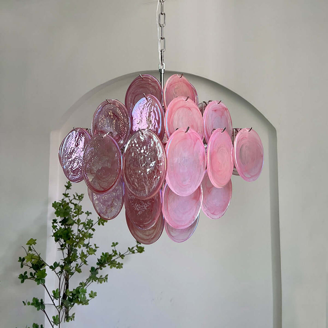 Pink Murano glass chandelier displayed beneath an arched opening in a bright modern interior