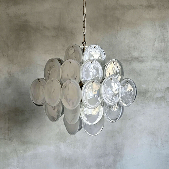 White Murano Disk Chandelier with clear textured glass discs against a gray concrete wall