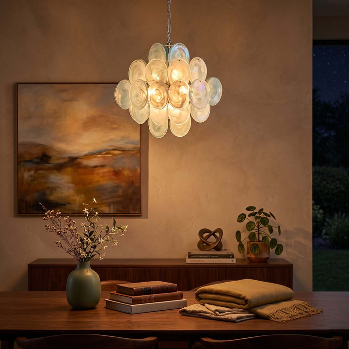 Glowing white Murano glass chandelier above a wood table in a warm evening interior
