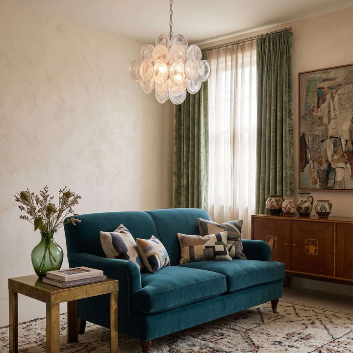 White Murano Disk Chandelier above a teal sofa in an eclectic living room