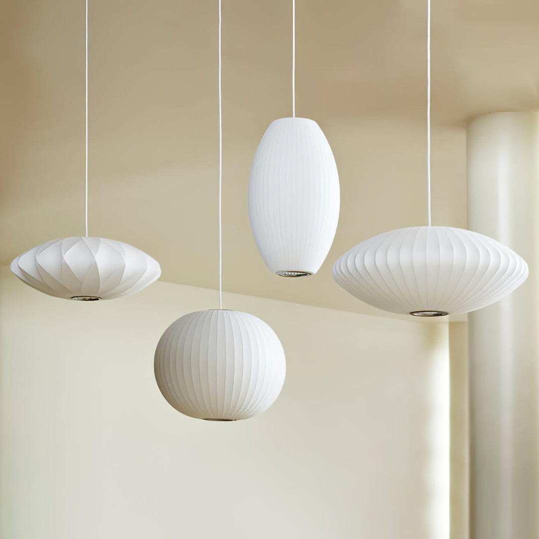 Four white Nelson Bubble pendant lamps in saucer, globe and oval shapes displayed in a modern interior