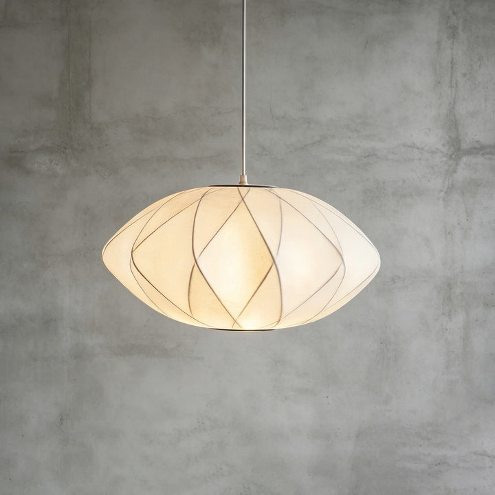 Geometric Nelson Bubble pendant light with intersecting frame lines against a textured concrete background