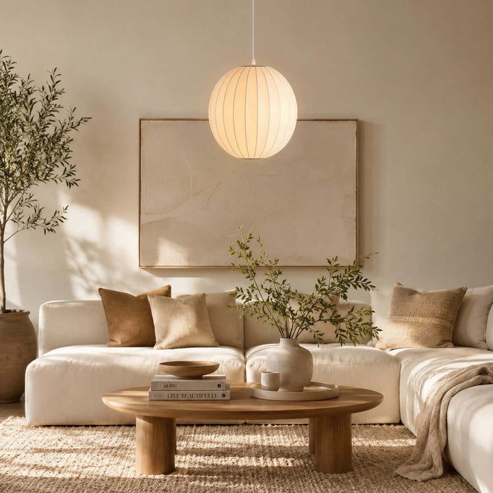 Round Nelson Bubble pendant light above a cream sectional sofa in a bright neutral living room