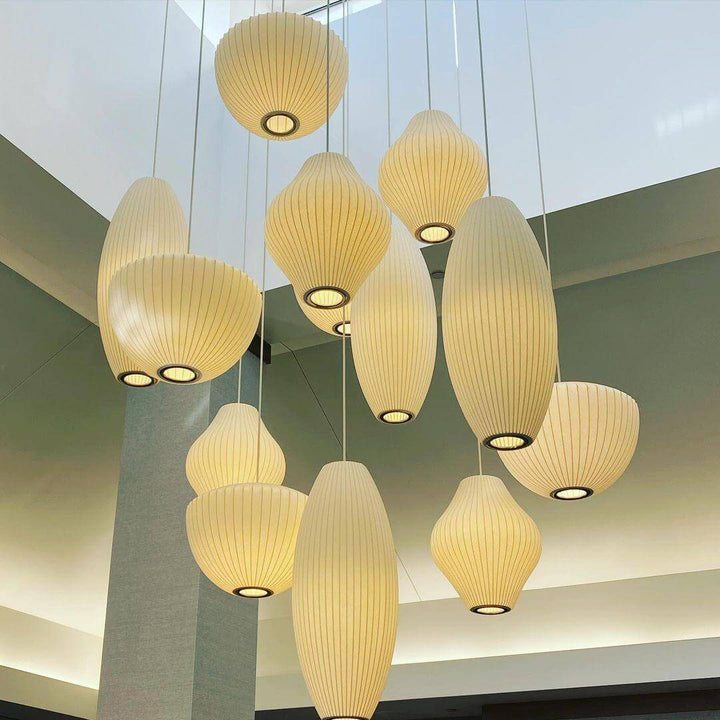 Large cluster of Nelson Bubble pendant lighting in mixed sculptural shapes suspended in a high-ceiling atrium