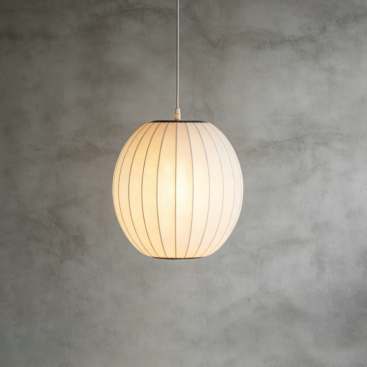 Rounded oval Nelson Bubble pendant lamp with a white ribbed shade against a textured concrete wall