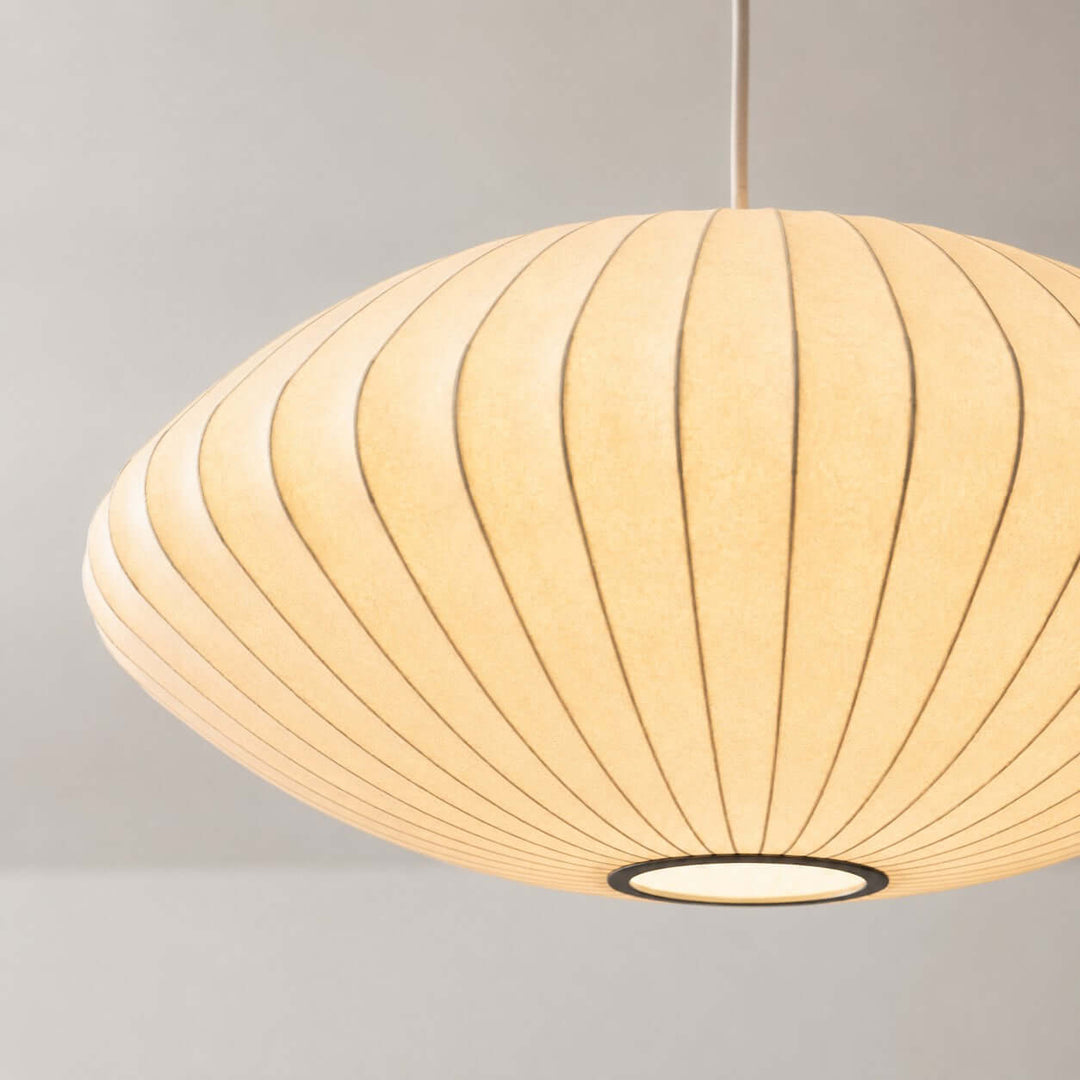 Close-up of the glowing ribbed silk shade and lower opening on the Nelson Bubble saucer pendant lamp