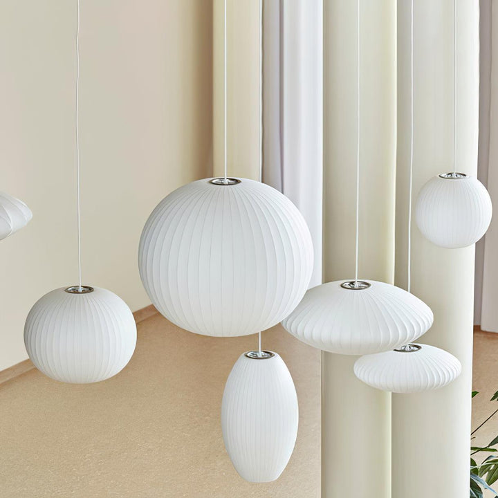 Collection of white Nelson Bubble pendant lamps in globe, saucer and oval shapes hanging in a modern stairwell
