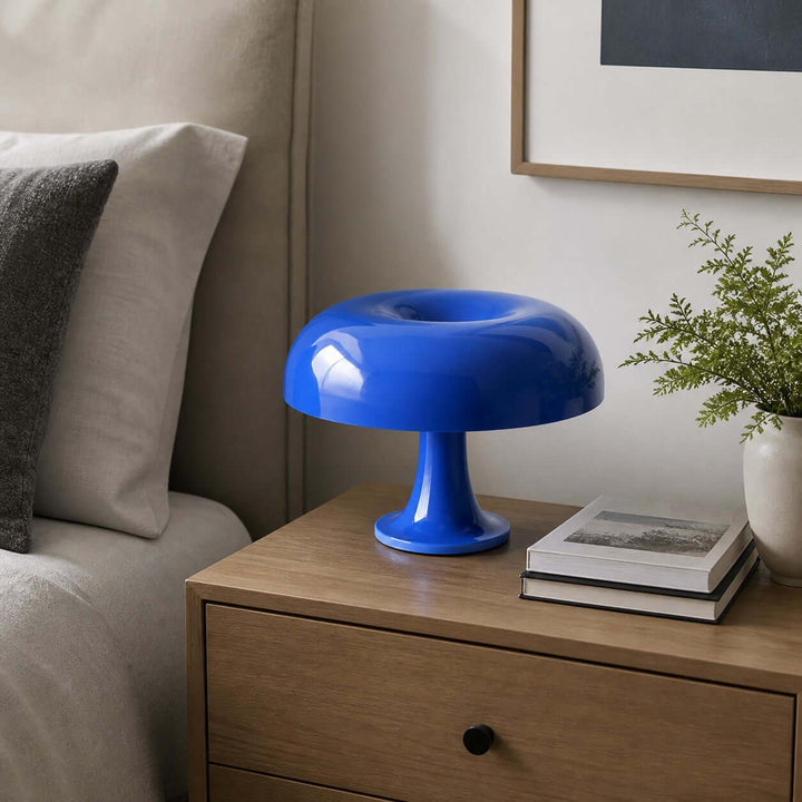 Blue Nesso Table Lamp on a wood nightstand beside a contemporary bed