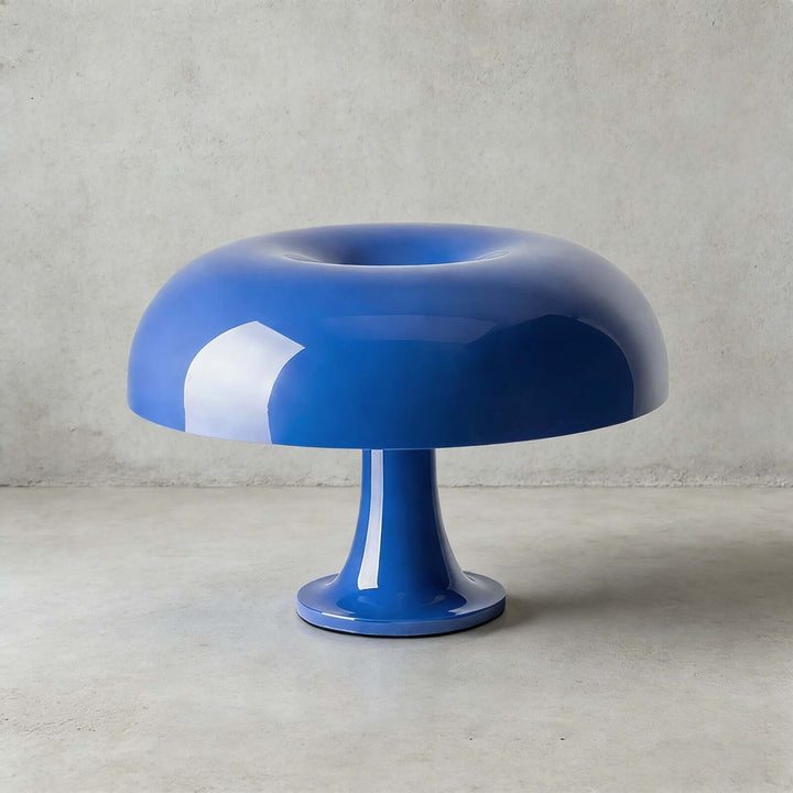 Blue Nesso Table Lamp with a rounded dome shade on a concrete surface