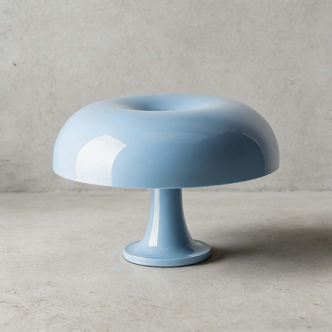 Light blue Nesso Table Lamp with a glossy finish against a concrete background