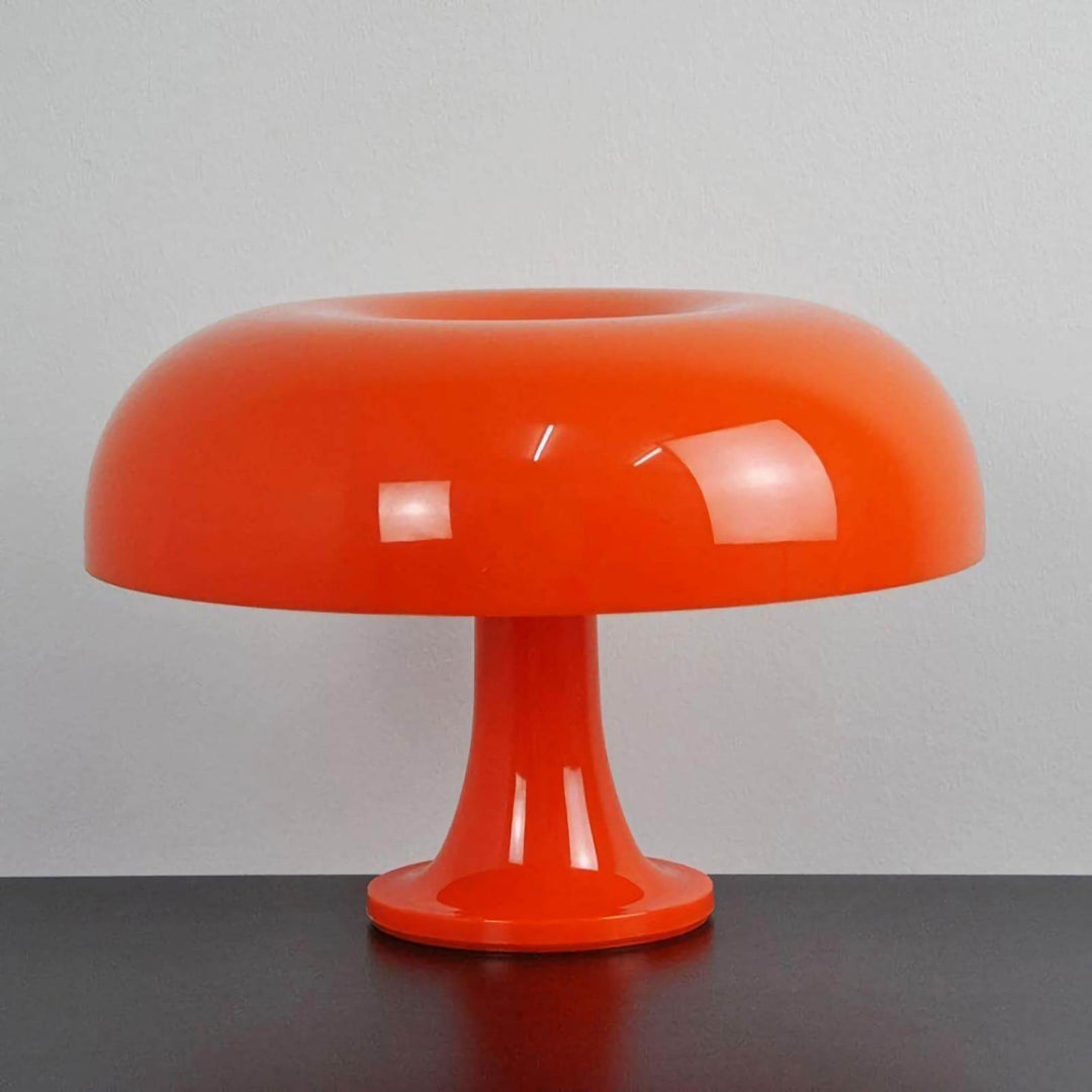 Front view of the orange Nesso Table Lamp on a dark tabletop
