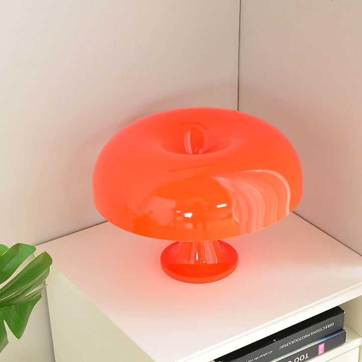 Angled close-up of the orange Nesso Table Lamp showing its sculpted dome shade