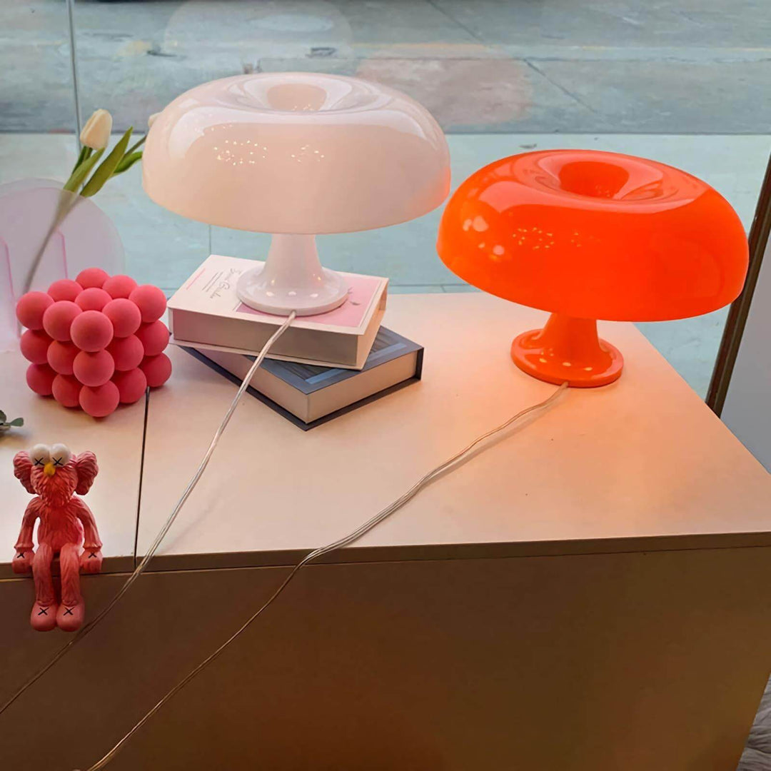 Orange and white Nesso Table Lamps displayed with books and colorful decor
