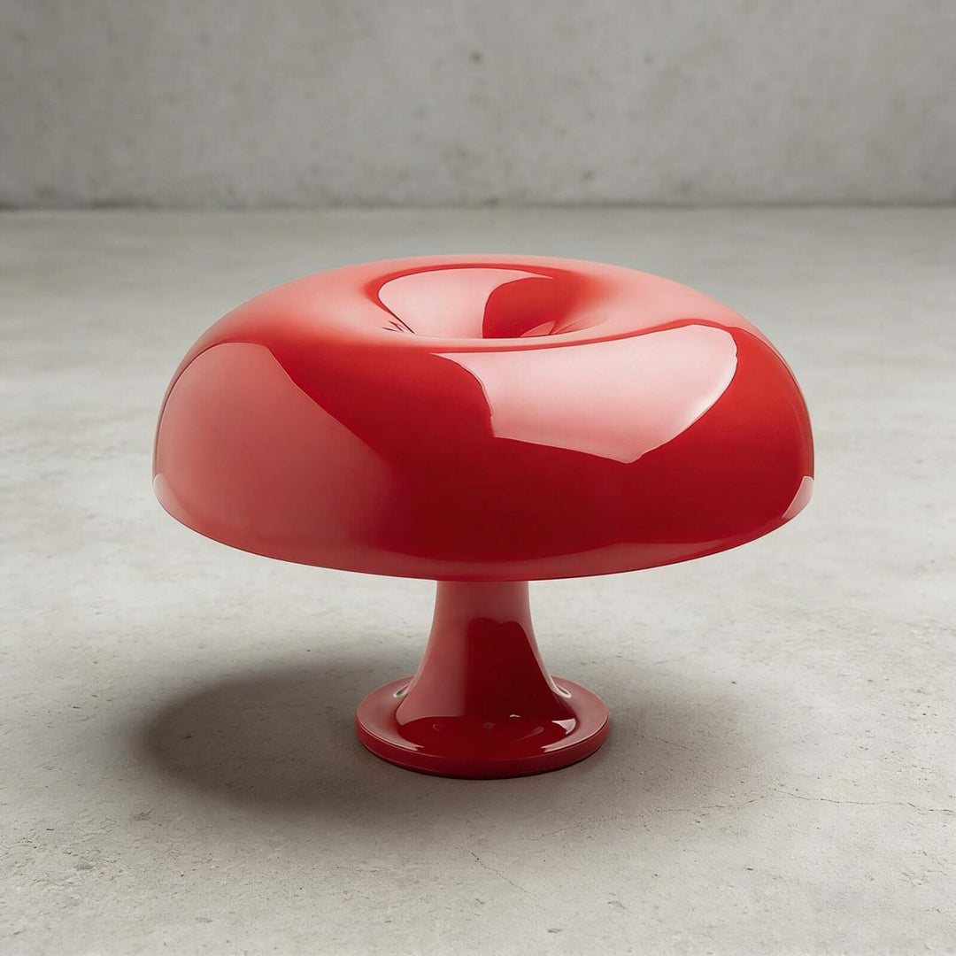 Red Nesso Table Lamp with a glossy sculptural shade against a concrete background