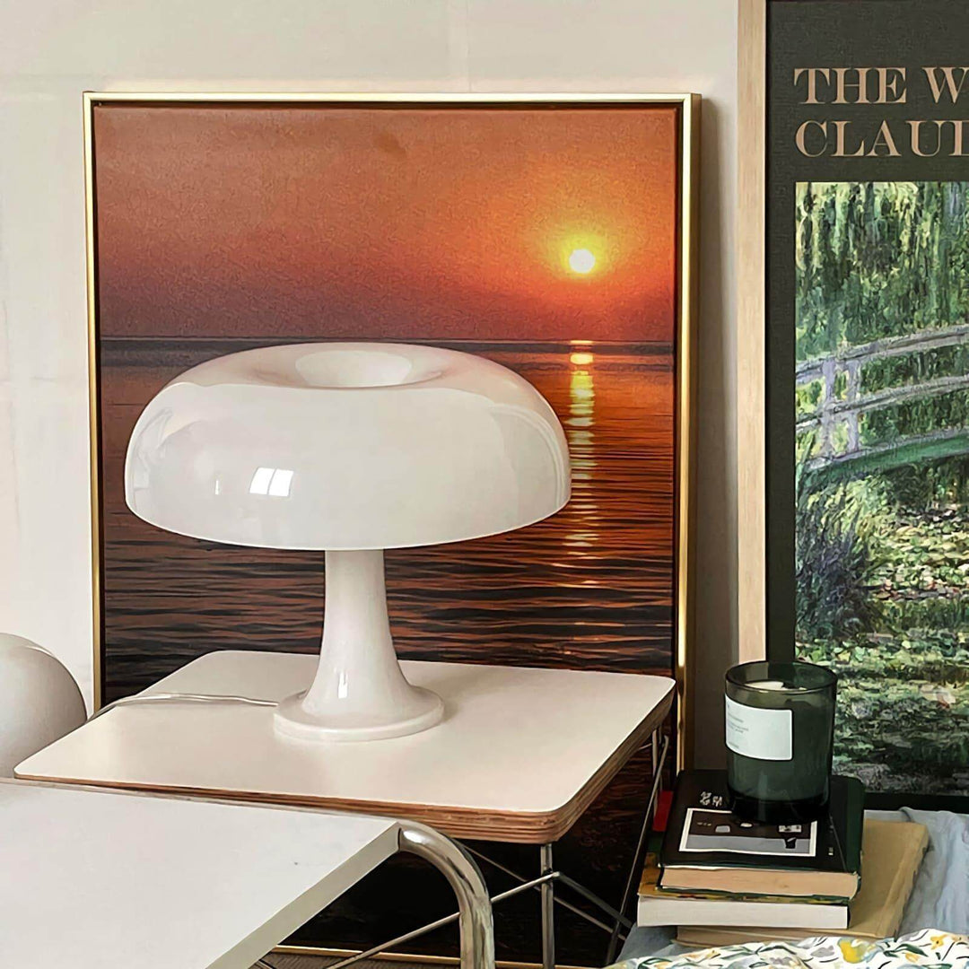 White Nesso Table Lamp on a side table in front of sunset wall artwork