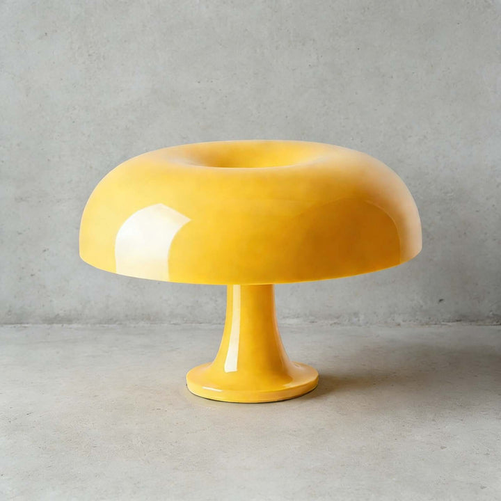 Yellow Nesso Table Lamp with a glossy acrylic finish on a concrete surface