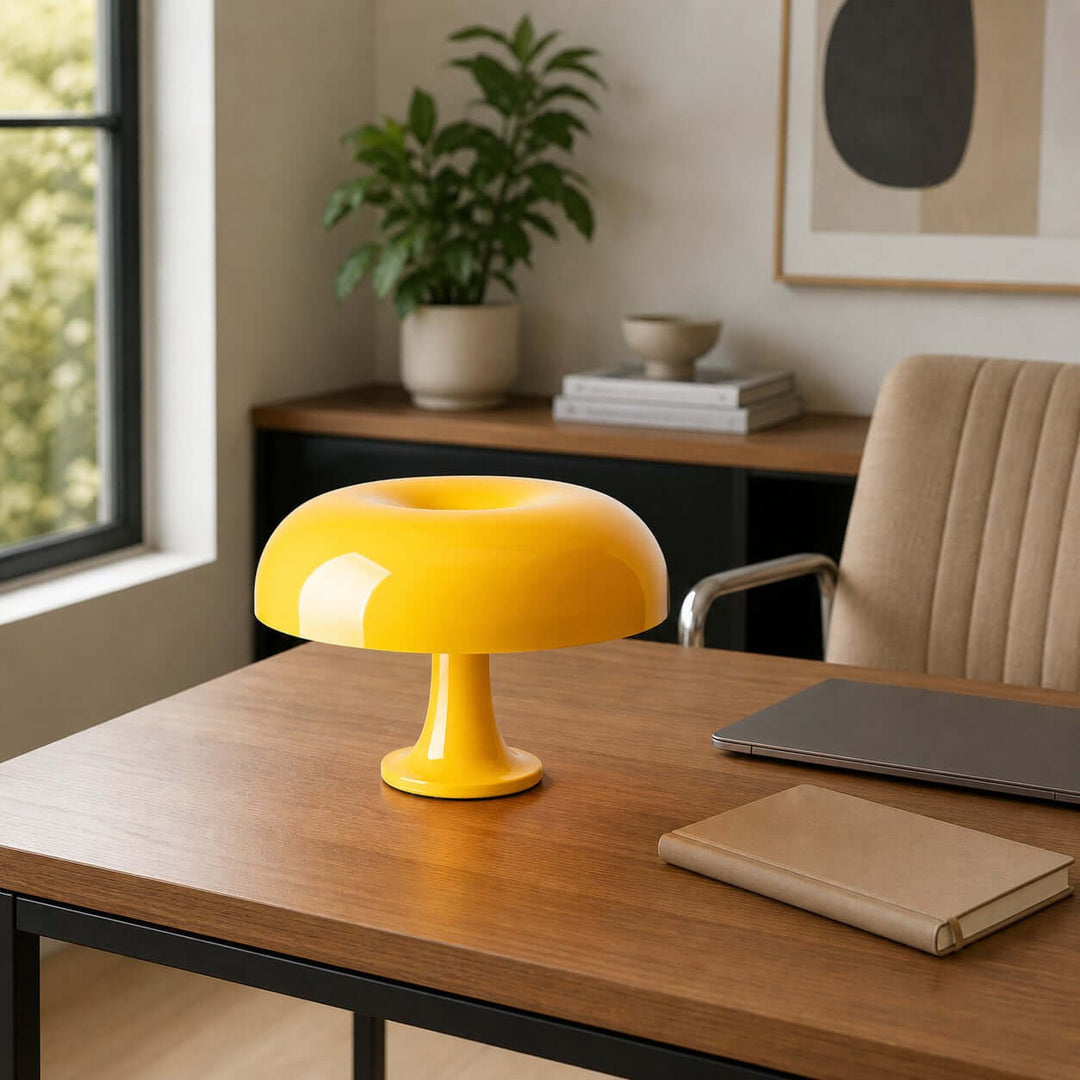 Yellow Nesso Table Lamp on a wood home office desk beside a laptop