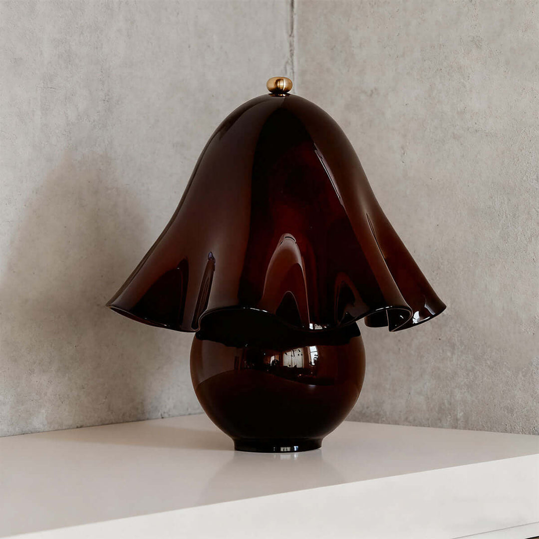 Smooth brown glass table lamp with glossy flower-shaped shade and round base