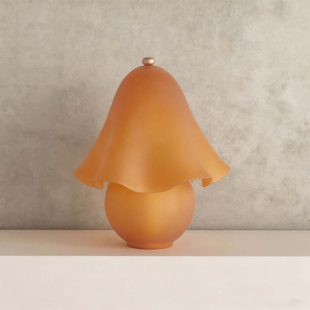 Smooth frosted amber glass table lamp with softly curved flower shade and round base