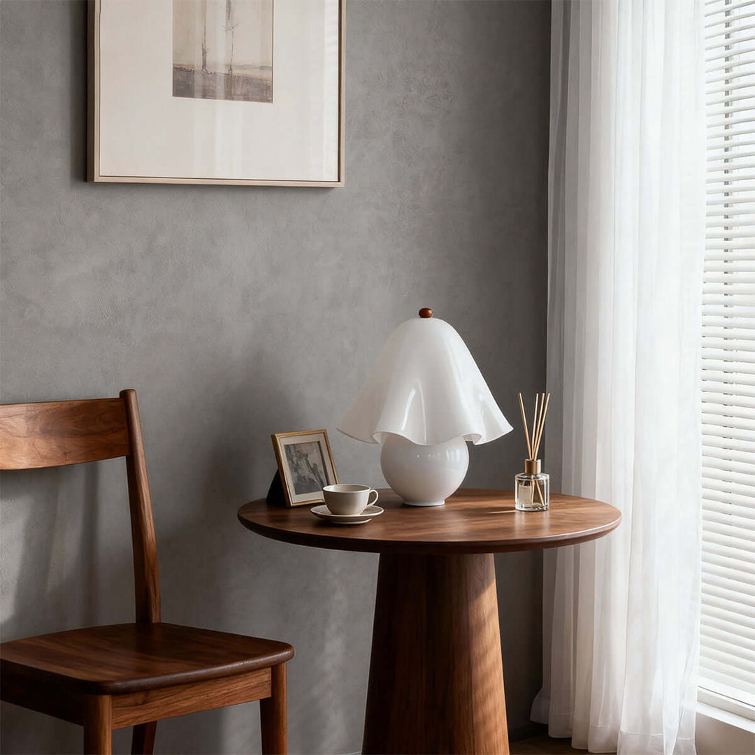 Smooth white glass table lamp on a round wood accent table in a modern interior
