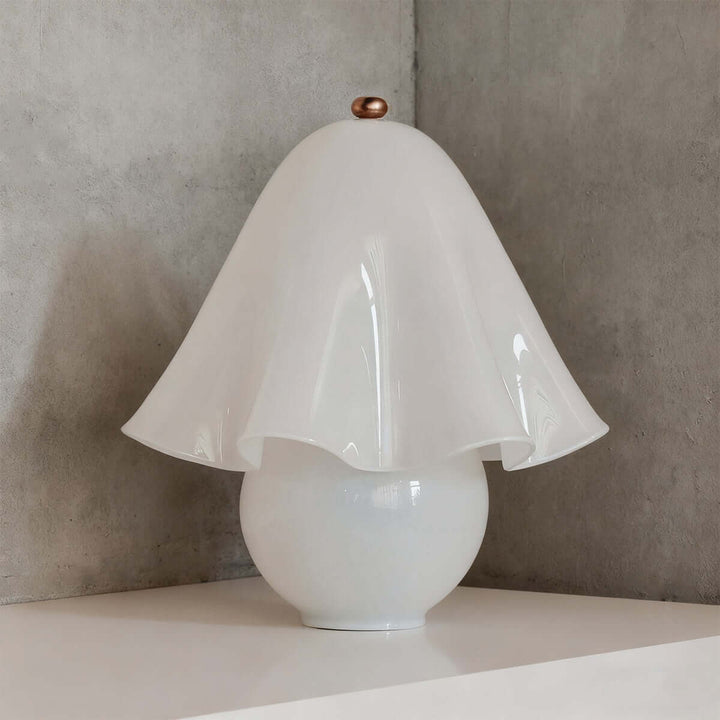 Smooth white glass table lamp with flowing floral shade and bronze finial