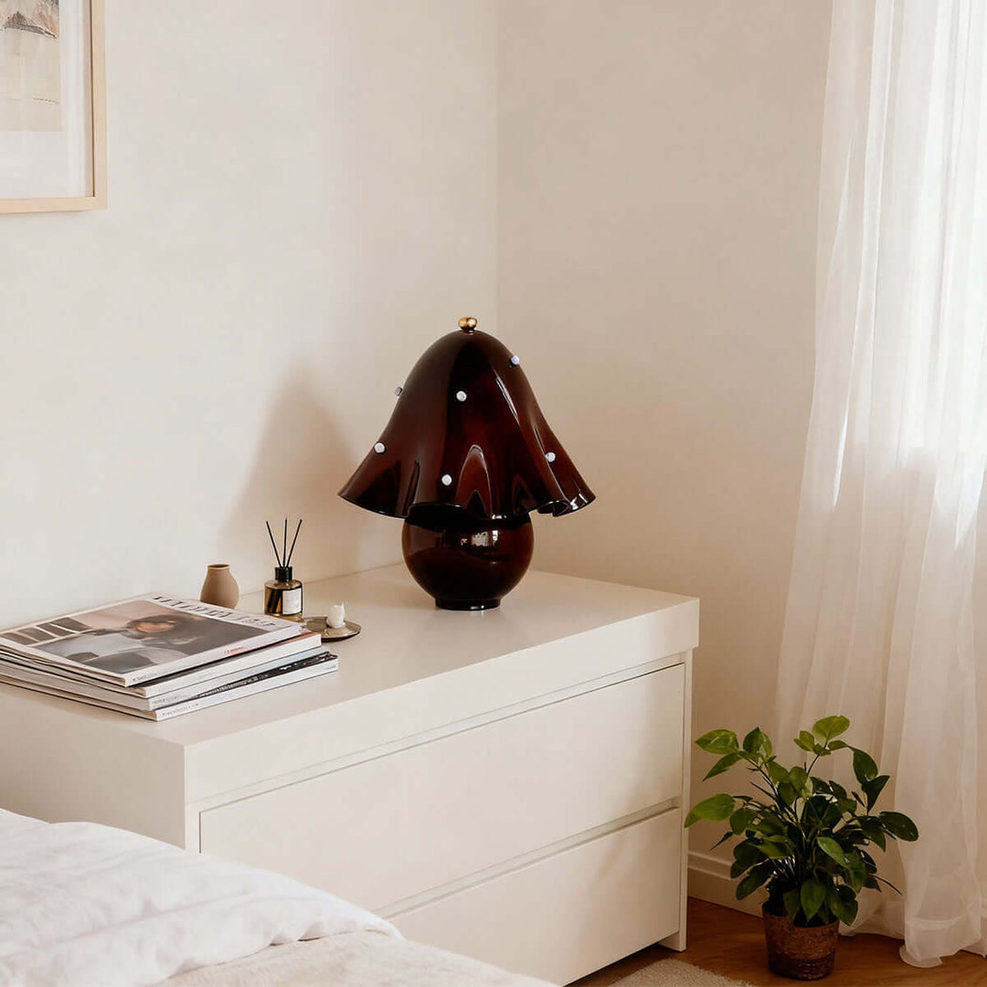 Spotted brown glass table lamp on a white bedroom dresser near a bright window