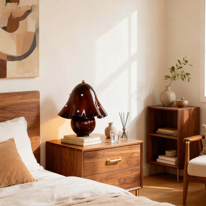 Spotted brown glass table lamp on a wood bedroom nightstand beside a neutral bed