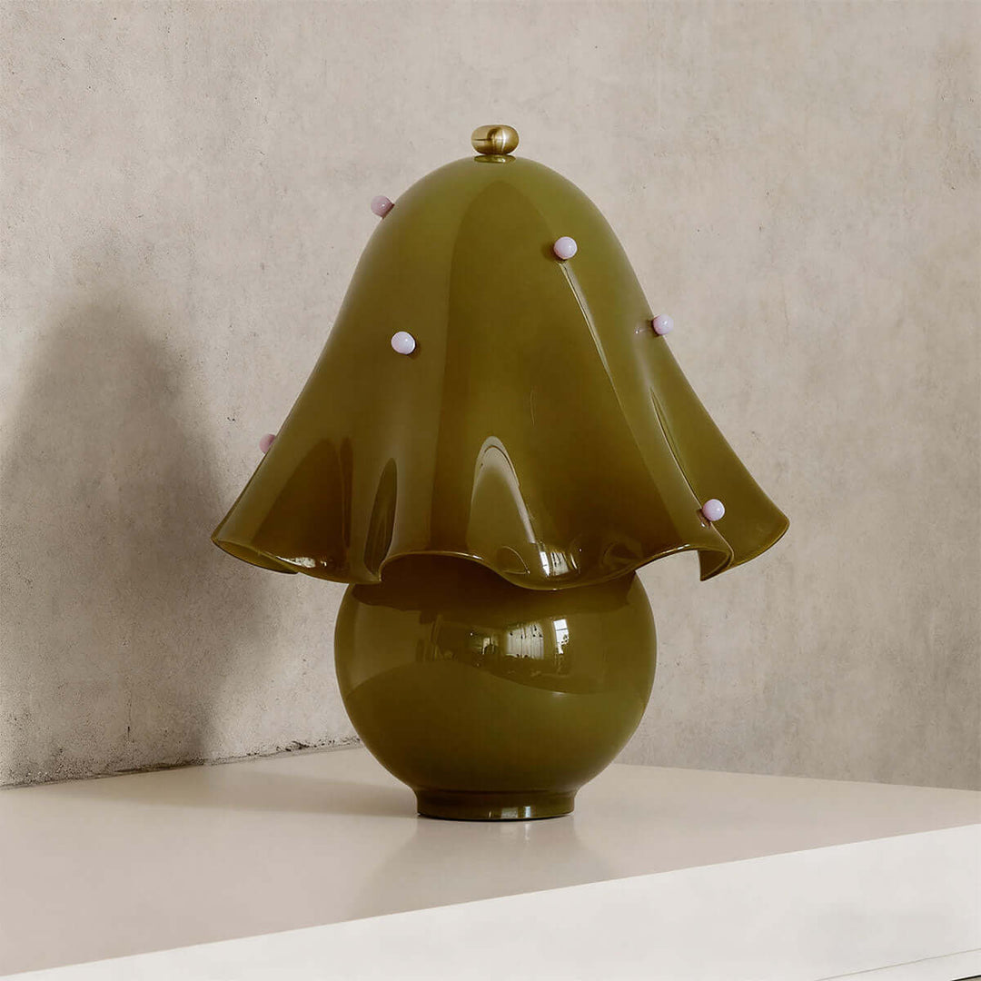 Spotted green glass table lamp with small pink decorative accents and flared flower shade