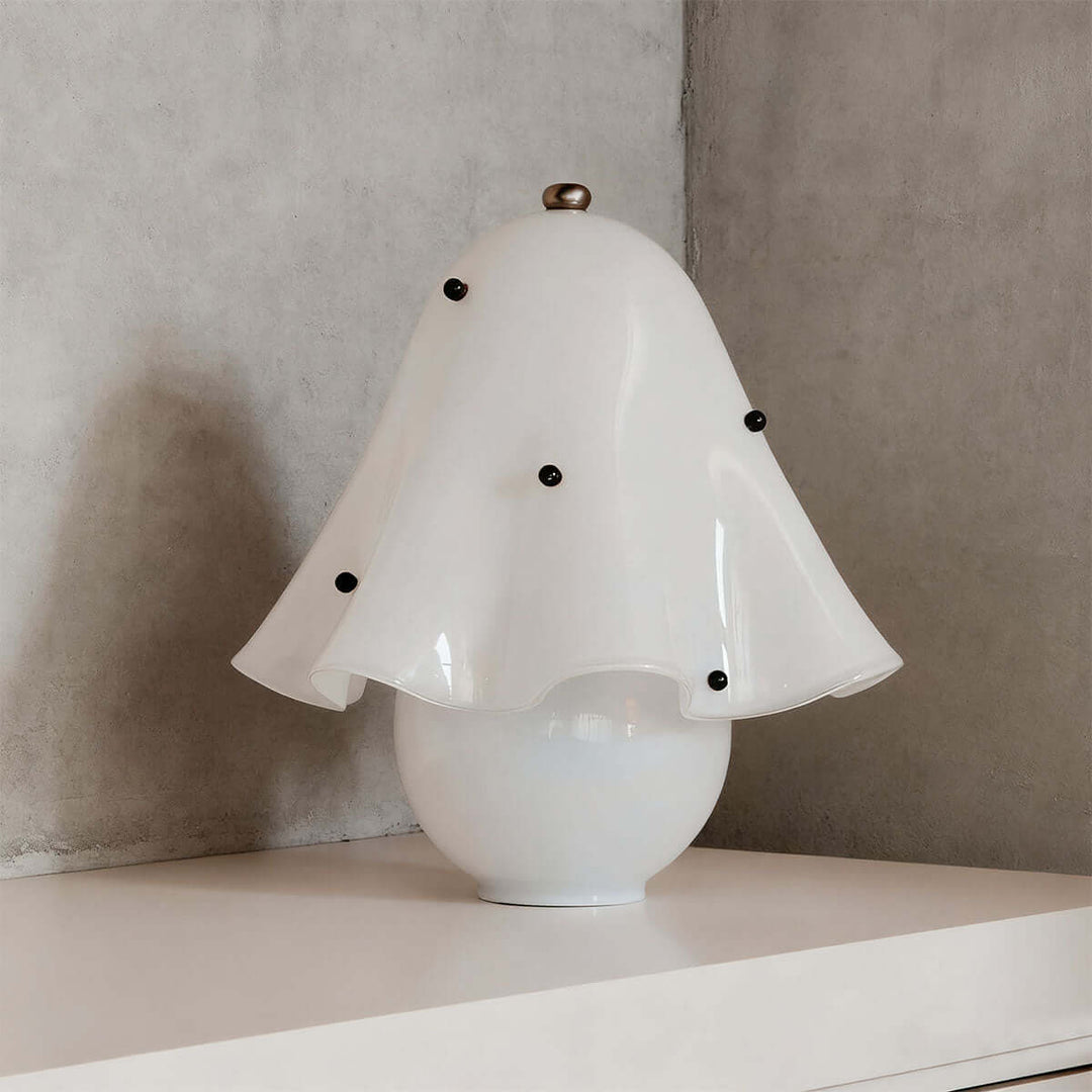 Spotted white glass table lamp with black decorative accents and sculptural shade