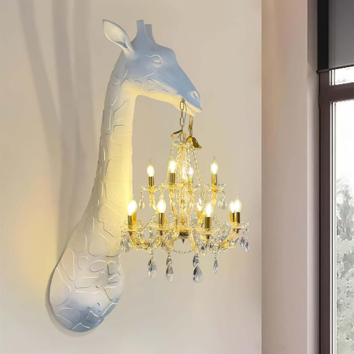 Close-up of the white Nuvexa Giraffe Wall Lamp holding an illuminated gold crystal chandelier beside a window