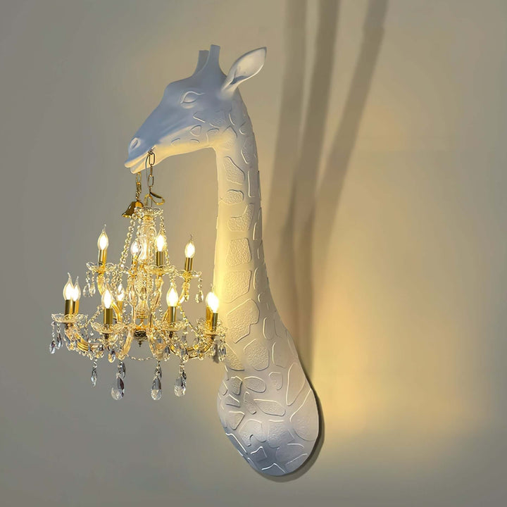 Angled view of the white and gold Nuvexa giraffe wall lamp with crystal drops and a warm wall shadow
