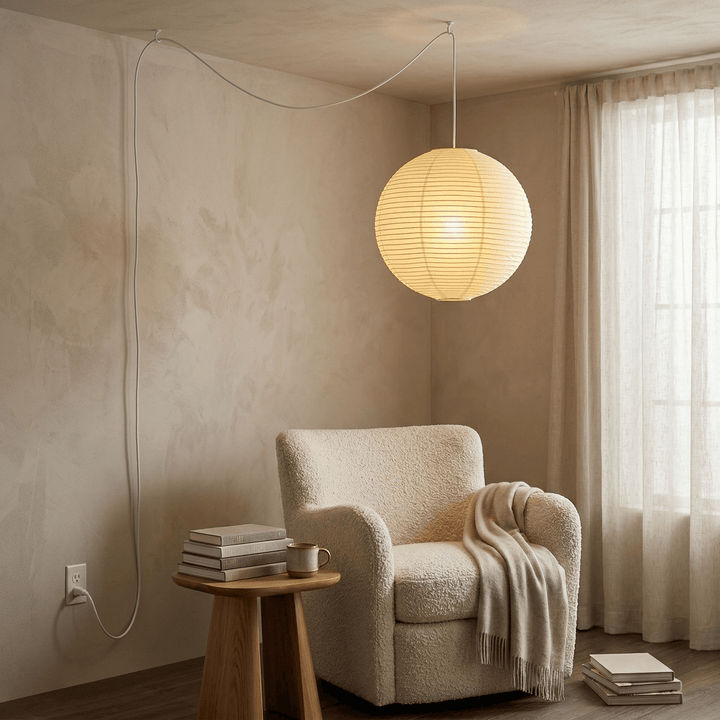Paper globe pendant light with optional plug-in cord above a reading chair
