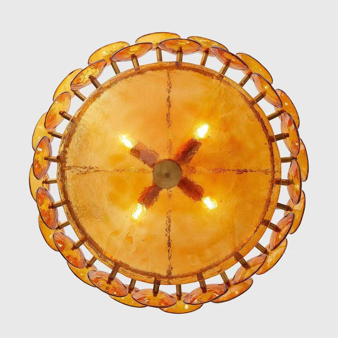 Illuminated bottom view of an orange glass chandelier with a textured glass bowl