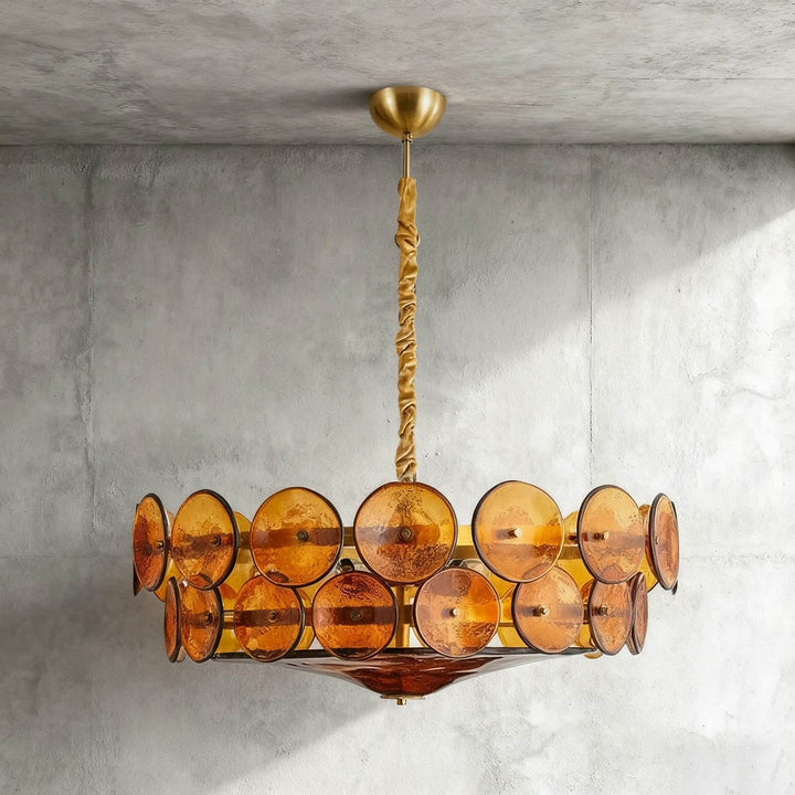 Front view of an orange glass disc chandelier with a round bronze frame