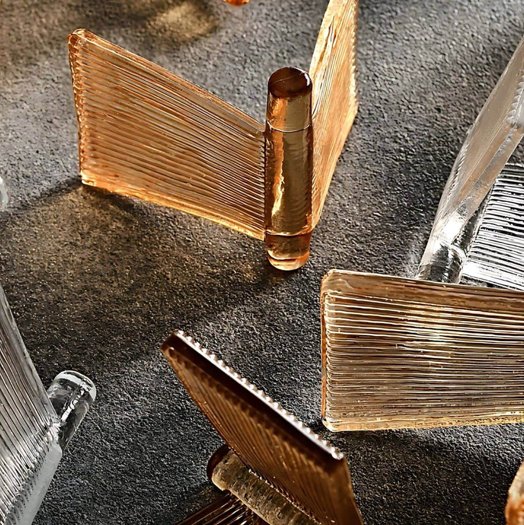 Amber and clear ribbed glass panels for the Orvex chandelier arranged on a dark surface