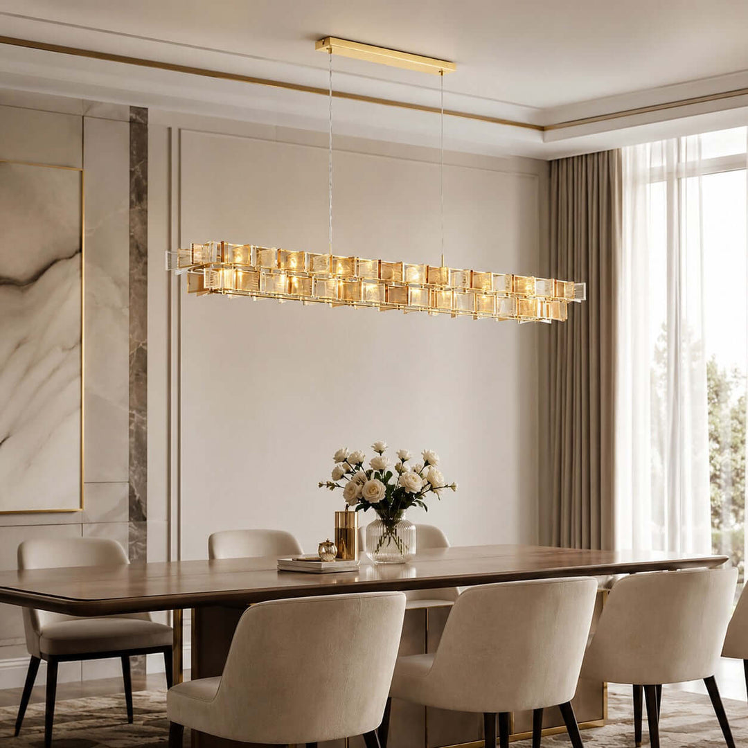 Amber Orvex linear dining room chandelier above a long wood table in a bright interior