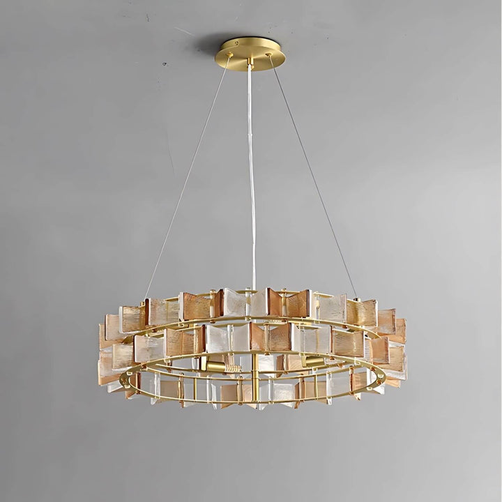Unlit amber Orvex round chandelier with clear and amber glass panels on a gray background