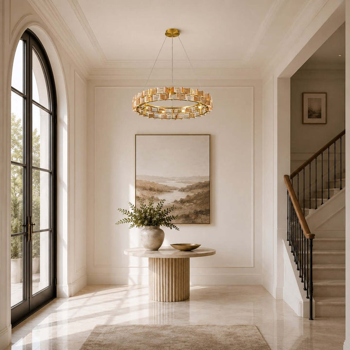 Amber Orvex round chandelier in a bright entryway beside an arched window and staircase