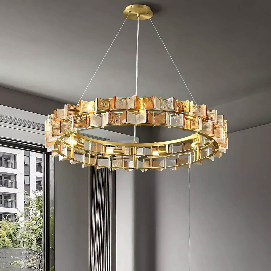 Amber Orvex round chandelier with layered glass panels installed near a floor-to-ceiling window