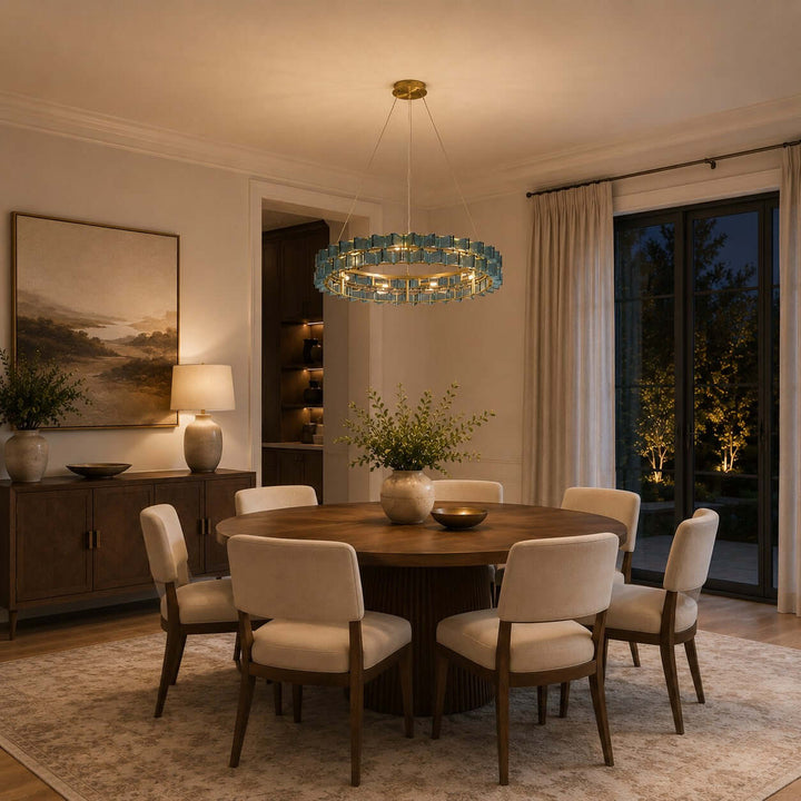 Blue glass Orvex dining room chandelier illuminating a round table in an evening interior