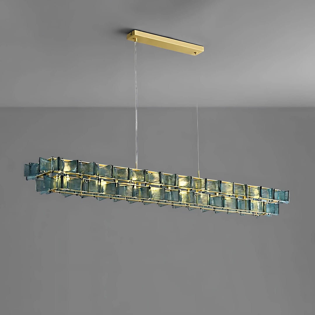 Blue Orvex linear chandelier shown from an angled side view on a gray background