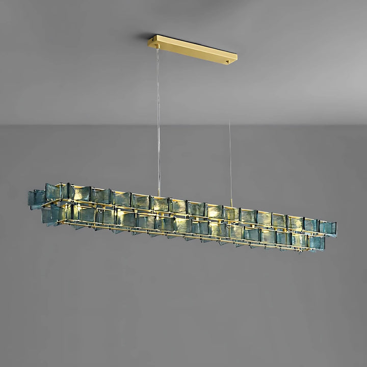Blue Orvex linear chandelier shown from an angled side view on a gray background