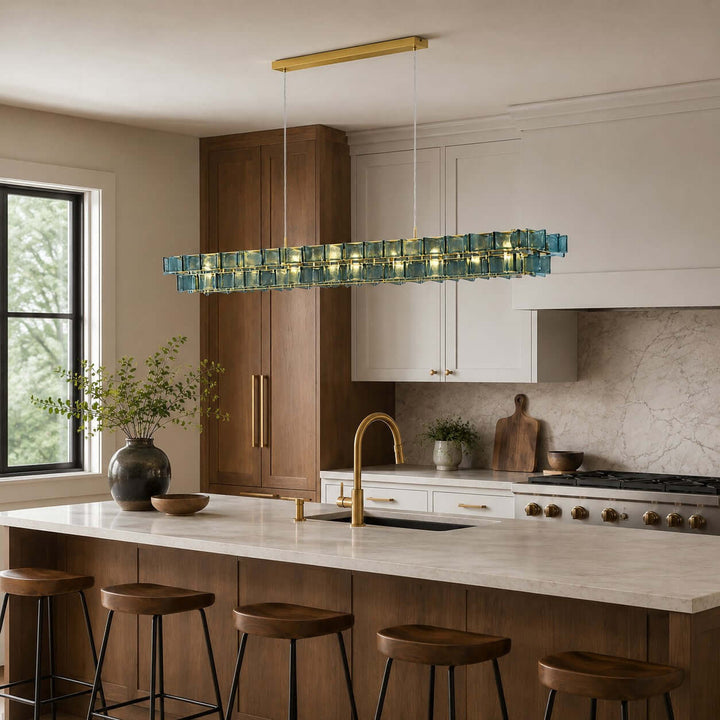Blue Orvex linear chandelier with textured glass panels above a modern kitchen island