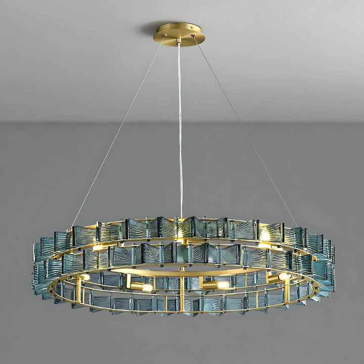 Blue Orvex round chandelier with a brushed gold frame on a gray background