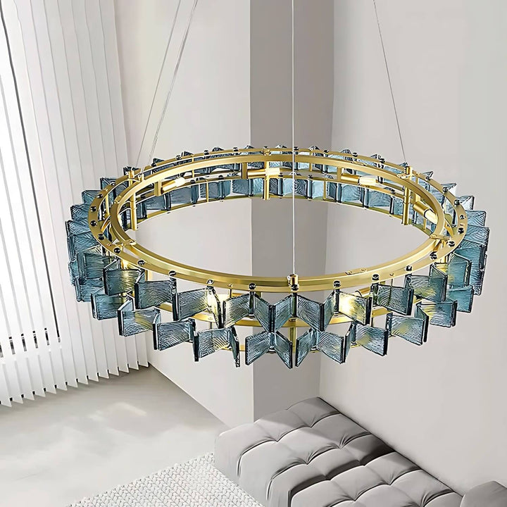 Close view of the blue Orvex round chandelier with layered textured glass and a gold frame