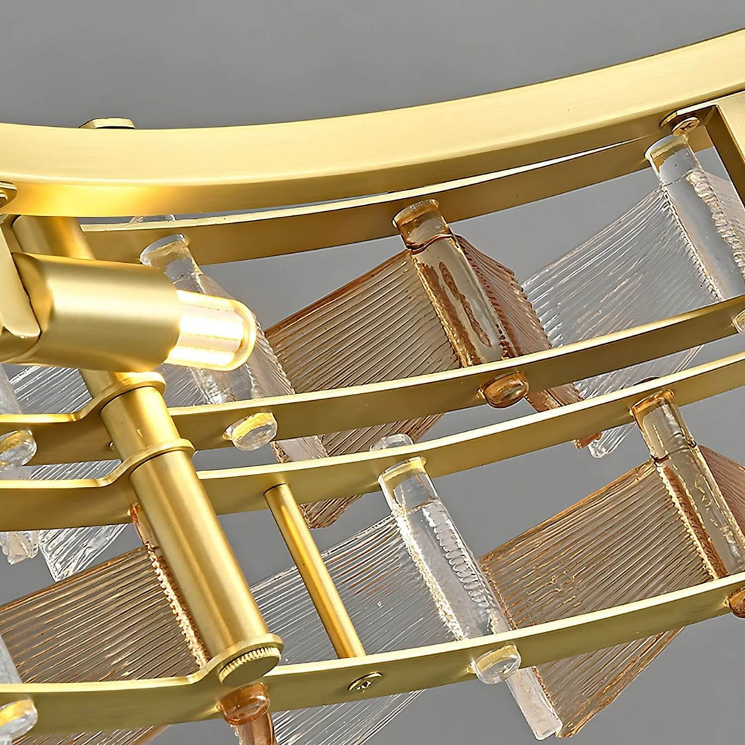 Underside detail of the Orvex chandelier showing the brushed gold frame, lights, and textured glass