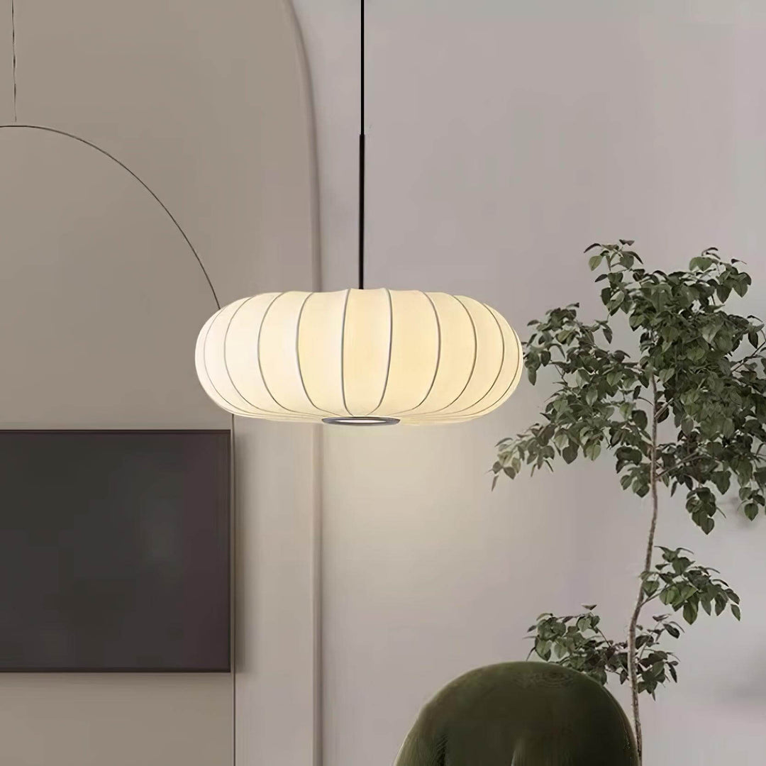 Glowing oval silk pendant light with a black cord in a minimalist living room